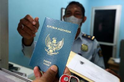 Petugas menyerahkan paspor kepada warga di kantor Imigrasi Kelas I Banda Aceh, Aceh, 26 Juli 2022. ANTARA/Irwansyah Putra