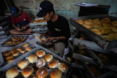 Pekerja mengemas roti yang siap di jual di kawasan Duren Sawit, Jakarta, 14 Februari 2022. Tempo/Tony Hartawan