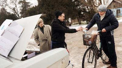 Seorang relawan memberikan makanan kepada warga dari mobilnya di sebuah desa, di Kherson, Ukraina 31 Januari 2023/REUTERS/Nacho Doce