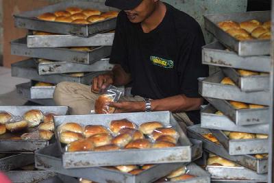 Pekerja tengah mengemas roti yang siap di jual di kawasan Duren Sawit, Jakarta, 14 Februari 2022. Tempo/Tony Hartawan