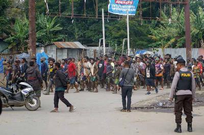 Sejumlah warga membawa senjata panah berjalan usai kerusuhan massa di Wamena, Papua, 24 Februari 2023. ANTARA/Iwan Adisaputra