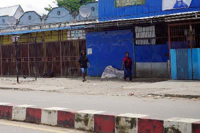 Dua warga melintasi pertokoan yang tutup pascabentokan warga di jalan Yos Sudarso Wamena, Provinsi Papua Pegunungan, 25 Februari 2023. ANTARA/Iwan Adisaputra
