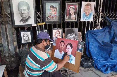 Pelukis sedang mengerjakan pesanan di area Kota Tua, Jakarta, 27 Februari 2023. Tempo/Ilona Esterina Piri