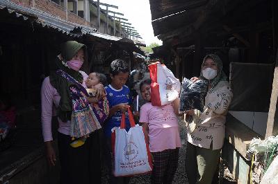 Warga menunjukan bantuan sosial berupa sembako saat kunjungan Presiden Joko Widodo di Pasar Baleendah, Kabupaten Bandung, Jawa Barat, 5 Maret 2023. TEMPO/Prima mulia