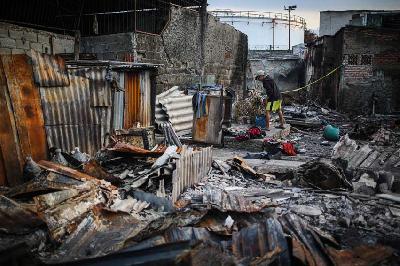Seorang anak mencari sisa barang di rumahnya yang hangus terbakar imbas kebakaran depo Pertamina Plumpang di Jalan Tanah Merah Bawah, Plumpang, Jakarta, 6 Maret 2023. TEMPO/Hilman Fathurrahman W
