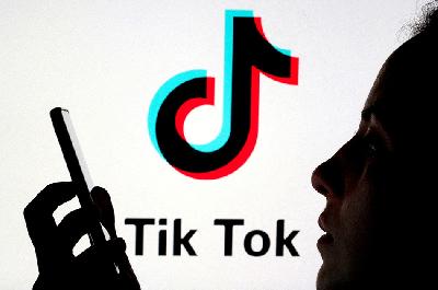 Pengguna memegang handphone di depan logo Tiktok .REUTERS/Dado RuvicPhoto