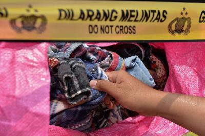 Petugas memeriksa baju bekas saat rilis kasus penyelundupan barang bekas dan ilegal di Polda Metro Jaya, Jakarta, 24 Maret 2023. TEMPO/ Febri Angga Palguna