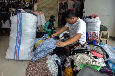 Pedagang menyortir pakaian impor bekas yang akan dijual di Pasar Senen, Jakarta. TEMPO/Tony Hartawan
