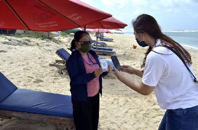 Pengunjung bertransaksi dengan pedagang pantai menggunakan Quick Response Code Indonesian Standard (QRIS) di Pantai Pandawa, Badung, Bali. ANTARA/Fikri Yusuf