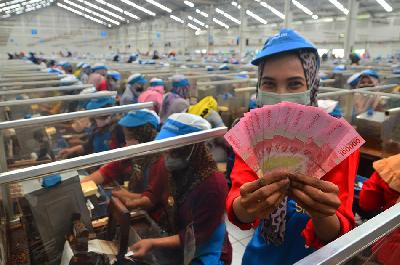Pekerja menunjukkan uang Tunjangan Hari Raya (THR) yang diterimanya di pabrik, Kudus, Jawa Tengah, 19 April 2022.. ANTARA/Yusuf Nugroho