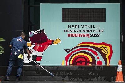 Petugas membersihkan lantai di dekat papan promosi Piala Dunia U-20 Indonesia 2023 di kawasan GBK Arena, Jakarta, 30 Maret 2023. ANTARA/Aprillio Akbar