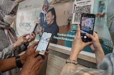 Warga memindai QRIS saat membayar donasi secara digital yang ditujukan kepada Yayasan BSMU-ZISWAF di Masjid BSI Wisma Mandiri, Jakarta, 11 April 2023. ANTARA/Muhammad Adimaja