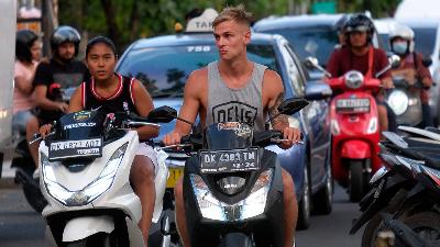 Foreign tourist rides a rented motorcycle without wearing a helmet In Jalan Pantai Kuta, Badung, Bali, March 13. 
ANTARA/Nyoman Hendra Wibowo
