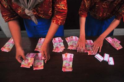Pekerja menghitung uang tunjangan hari raya (THR) yang diterimanya saat pembagian di pabrik rokok PT Djarum, Kudus, Jawa Tengah, 11 April 2023. ANTARA/Yusuf Nugroho