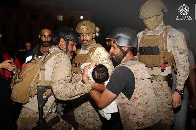 Tentara Kerajaan Saudi menggendong seorang anak saat mengevakuasi warga Saudi dan warga negara lainnya melalui Kapal Angkatan Laut Saudi di Port Sudan, Sudan, 22 April 2023.  REUTERS/Kementerian Pertahanan Saudi