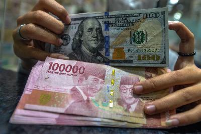 Petugas penukaran matau uang asing menghitung uang dolar amerika setikat dan rupiah di Jakarta. TEMPO/Tony Hartawan