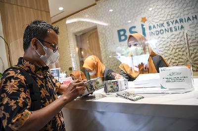 Nasabah membawa uang dolar AS usai bertransaksi di Kantor Cabang Bank Syariah Indonesia  (BSI)  Jakarta Thamrin, Jakarta, 11 Mei 2023.  ANTARA/M Risyal Hidayat