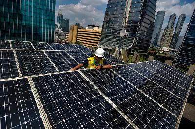 Pekerja tengah melakukan perawatan panel surya di salah satu gedung perkantoran di Jakarta, 5 Mei 2023. Tempo/Tony Hartawan