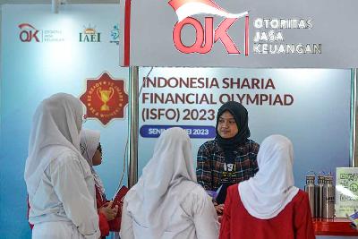Petugas Otoritas Jasa Keuangan (OJK) menjelaskan literasi keuangan kepada Siswi saat menghadiri acara Indonesia Sharia Financial Olympiad (ISFO) 2023 di Jakarta, 22 Mei 2023. Tempo/Tony Hartawan