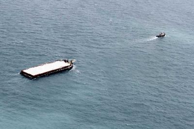 Sebuah kapal tunda menarik tongkang berisi pasir laut yang akan dibawa ke Singapura, di perairan Kepulauan Riau. ANTARA/Joko Sulistyo