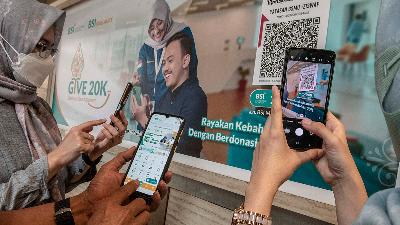 Customers pay infaq (donation) through QRIS-based digital services available on Bank Sharia Indonesia’s mobile phone application, April 11. 
ANTARA/Muhammad Adimaja
