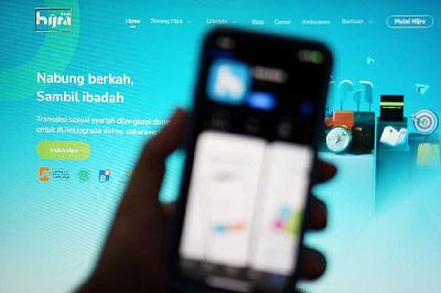 Pengguna membuka aplikasi Bank Hijra di Bogor, 29 Mei 2023. Tempo/Bintari Rahmanita