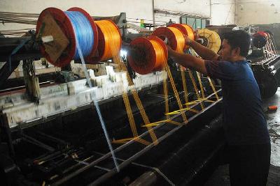Pekerja menjalankan mesin tenun di pabrik kain Kampung Balekambang, Kecamatan Majalaya, Kabupaten Bandung, Jawa Barat, 29 Desember 2022. TEMPO/Prima Mulia