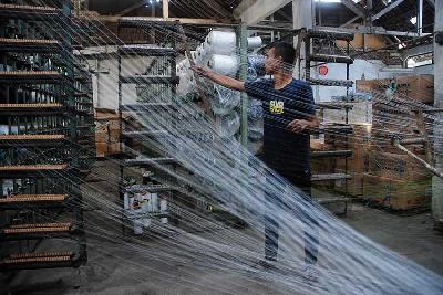 Pekerja mengatur alur benang di sebuah pabrik kain di Desa Rancajigang, Kecamatan Majalaya, Kabupaten Bandung, Jawa Barat. TEMPO/Prima Mulia