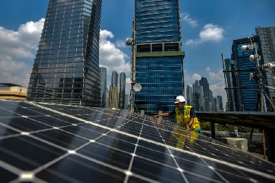 Pekerja melakukan perawatan panel surya di salah satu gedung perkantoran di Jakarta, 5 Mei 2023. TEMPO/Tony Hartawan