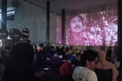 Penonton menyaksikan layar tancap film Koboi Insyaf, Benyamin Sueb di Taman Ismail Marzuki, Cikini, 25 Juni 2023. Tempo/ Ilona Esterina