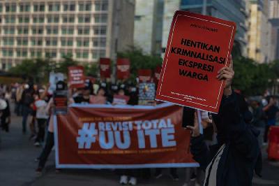 Aktivis Paguyuban Korban Kriminalisasi UU ITE (PAKU ITE) membentangkan poster saat menggelar aksi di kawasan Bundaran HI, Jakarta, 28 Mei 2023. TEMPO/M Taufan Rengganis