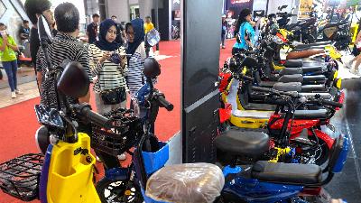 Pengunjung melihat brosur sepeda motor listrik di arena Jakarta Fair Kemayoran, 7 Juli 2023. Tempo/Tony Hartawan
