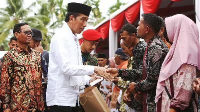 President Joko Widodo (white shirt) accompanied by Coordinating Minister for Political, Legal, and Security Affairs Mahfud MD (left) hands out aid to victims and offspring of victims of human rights violations, after declaring the settlement of gross human rights violations at the Rumoh Geudong in Bili Aron village, Pidie Regency, Aceh, June 27.
ANTARA PHOTO/Khalis Surry
