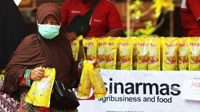 A woman buys Sinarmas cooking oil products during a cheap cooking oil market held at the Jemur Wonosari subdistrict office, Surabaya, East Java, January 21, 2022. 
ANTARA/Didik Suhartono/File Photo
