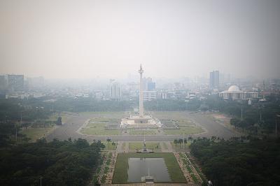 Tugu Monas terlihat samar karena polusi udara di Jakarta, 25 Juli 2023. TEMPO/Hilman Fathurrahman W