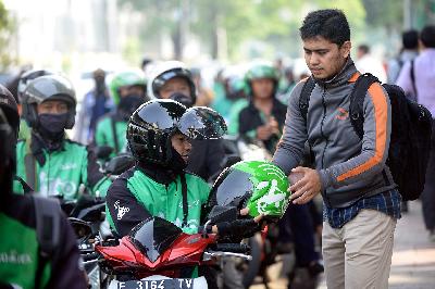 Pengemudi ojek online setelah mengantar penumpang di kawasan Palmerah, Jakarta. TEMPO/Tony Hartawan
