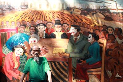 Pelukis Djoko Pekik dengan latar lukisan karyanya berjudul "Petruk Mantu Putra Koalisi"  di rumahnya, di Bantul,Yogyakarta, 26 November 2011. TEMPO/Arif Zulkifli