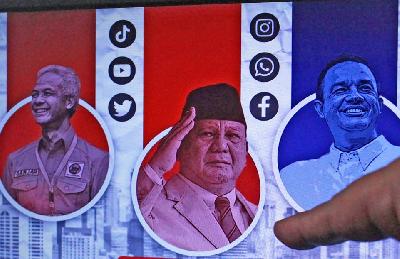 Seorang jurnalis memperhatikan survei calon presiden di Jakarta, 10 Juli 2023. ANTARA/Reno Esnir