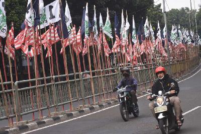 Pengendara melintas di dekat bendera parpol yang terpasang di kawasan Tebet, Jakarta, 17 Juli 2023. ANTARA/Indrianto Eko Suwarso