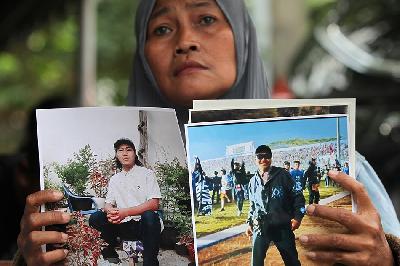 Orang tua korban tragedi Kanjuruhan Rini Hanifah menunjukkan foto putranya, Agus Riansyah, saat sidang di Pengadilan Negeri Surabaya, Jawa Timur, 16 Januari 2023. ANTARA/Didik Suhartono