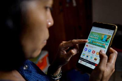 Pengguna telepon pintar tengah melihat aplikasi Akulaku di Jakarta. Tempo/Tony Hartawan