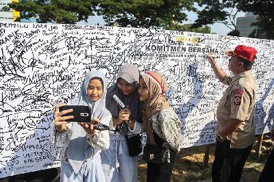 Sejumlah warga berswafoto dengan latar belakang papan tanda tangan Deklarasi Pemilu Damai 2024 di Lapangan Pancasila, Semarang, Jawa Tengah, 3 September 2023. ANTARA/Makna Zaezar