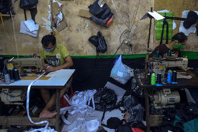 Pekerja meyelesaikan pembuatan produk UMKM di Manggarai, Jakarta. TEMPO/Tony Hartawan