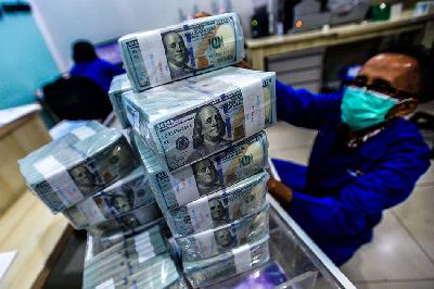 Pekerja memindahkan uang dolar Amerika Serikat di cash center Bank Mandiri, Jakarta. TEMPO/Tony Hartawan