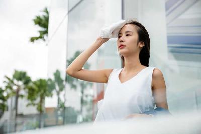 Seorang wanita mengeringkan keringat saat gelombang panas. Shutterstock