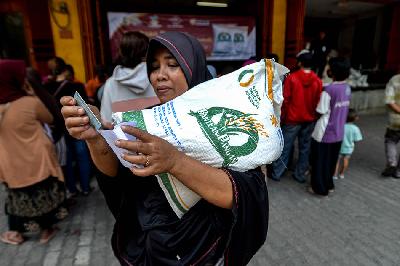 Keluarga Penerima Manfaat (KPM) membawa beras bantuan sosial (bansos) pangan di Kantor Pos Tanjung Priok, Jakarta, 19 September 2023.  TEMPO/Tony Hartawan