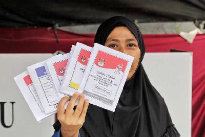 Warga menunjukkan surat suara di Tangerang Selatan, 2019. Tempo/Hilman Fathurrahman W