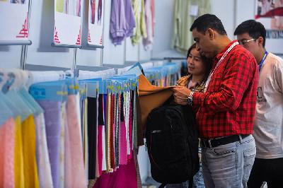 Pengunjung melihat kain dalam pameran produk "China Homelife Indonesia" yang diikuti sekitar 700 suplier asal Cina di Jakarta International Expo, Kemayoran, Jakarta, 17 Maret 2023. TEMPO/Tony Hartawan