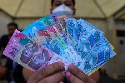 Petugas menunjukkan uang rupiah kertas tahun emisi 2022 pada Festival Rupiah Berdaulat Bank Indonesia di Jakarta, Agustus 2022. Tempo/Tony Hartawan