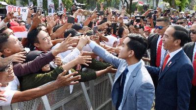 Presiden Joko Widodo dan Gibran Rakabuming Raka menyarpa warga di lingkungan Istana Merdeka, Jakarta, Oktober 2019. BPMI Setpres/Muchlis Jr
